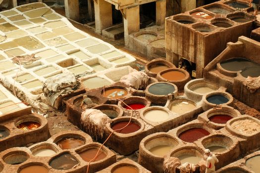 A vibrant aerial view of the traditional tanneries in Fes, Morocco, showcasing the dyeing process.